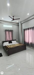 a bedroom with a bed with a ceiling fan at Sree jee stay in Varanasi