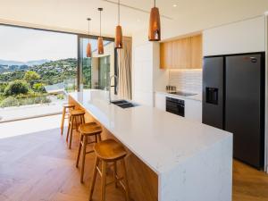 a kitchen with a white counter top and a large window at Renard Retreat in Akaroa +19 photos