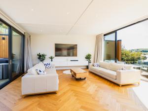 a living room with white furniture and large windows at Renard Retreat in Akaroa
