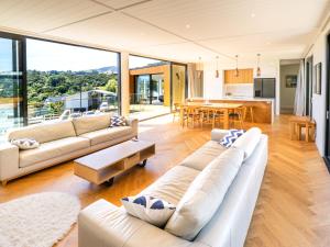 a living room with two couches and a table at Renard Retreat in Akaroa