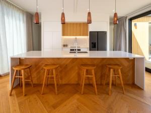a kitchen with a large island with bar stools at Renard Retreat in Akaroa