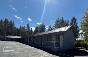 a building in a parking lot with trees in the background at Tahoe Sands Inn in South Lake Tahoe