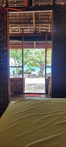 a window in a room with a view of a tree at Mananambal Beach Huts - Hut 2 in Nagbalaye