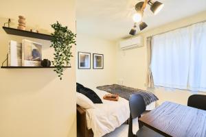 a room with a bed and a table and a window at Reberty Haneda in Tokyo