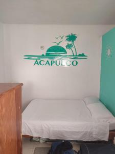 a bedroom with a bed with a sign on the wall at Departamento Acapulco tres mares in Acapulco +15 photos