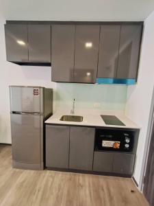a kitchen with a sink and a stainless steel refrigerator at The8collaction in Bangkok