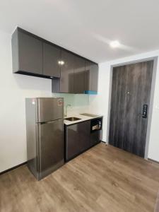 a kitchen with a stainless steel refrigerator and wooden floors at The8collaction in Bangkok
