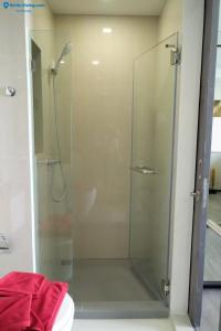 a glass shower in a bathroom with a toilet at The8collaction in Bangkok