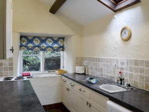 a kitchen with a counter and a sink and a window at Crogen Bryn Awel in Llandrillo