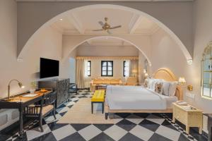 a bedroom with a large bed and a living room at lebua Udaipur Daulatgarh in Udaipur +38 photos