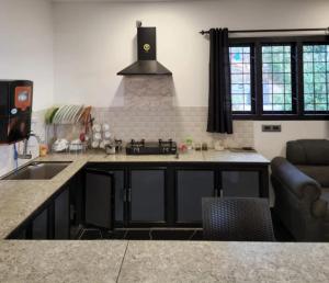 a kitchen with a sink and a stove top oven at Green Lounge in Munnar +21 photos