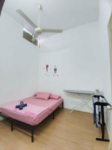 a bed in a room with a ceiling fan at 571 Seroja Homestay in Sungai Petani