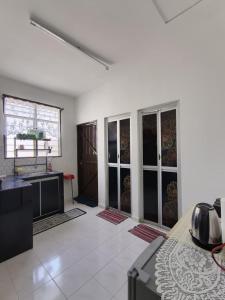 a white room with a kitchen and a room with a bed at 571 Seroja Homestay in Sungai Petani