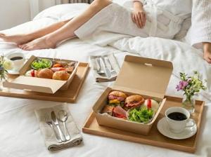 a person sitting on a bed with two boxes of food at Kamishichiken Oku in Kyoto