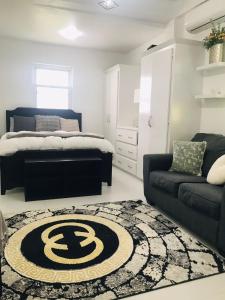 a bedroom with a bed and a couch and a rug at Casa Bonita GLAM in Castries