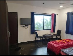 a bedroom with a bed and a desk and a window at Green Lounge in Munnar