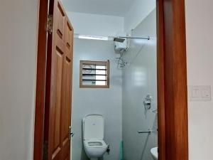 a bathroom with a toilet and a window at Haya podes in Vypīn +24 photos
