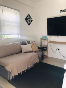 a living room with a couch and a flat screen tv at Casa Bonita GLAM in Castries