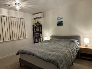 a bedroom with a bed and two night stands and a window at A cozy room with ensuite in Springvale, in a shared accommodation in Springvale