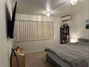 a bedroom with a bed and a large window at A cozy room with ensuite in Springvale, in a shared accommodation in Springvale