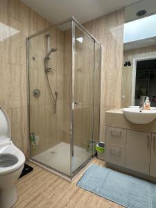 a bathroom with a shower and a toilet and a sink at A cozy room with ensuite in Springvale, in a shared accommodation in Springvale