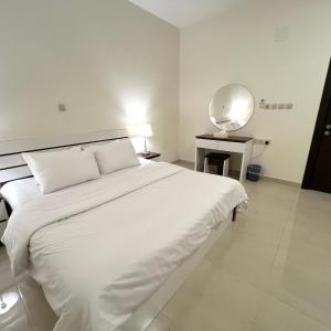 a large white bed in a room with a mirror at اكنان للشقق المفروشة in Buraydah