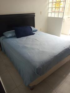 a large bed with a blue comforter in a bedroom at Villa en Terrasol Diamante in Acapulco +5 photos