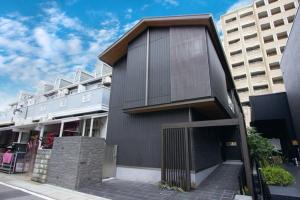 a contemporary house with a black facade at Fam Hotel Imaizumi in Fukuoka