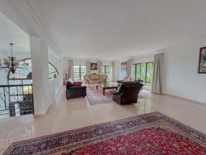 a living room with two couches and a rug at Miyanwe Guest House - Waterkloof in Pretoria