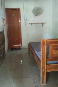 a small room with a bed and a door at Penginapan Joko Samudro in Baron +5 photos