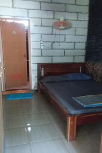 a bedroom with a bed and a brick wall at Penginapan Joko Samudro in Baron