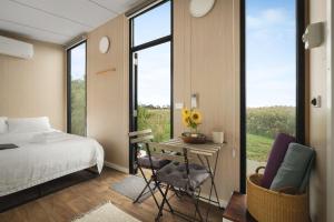 a bedroom with a bed and a table and chairs at Revillaging Project by Tiny Away in Boneo