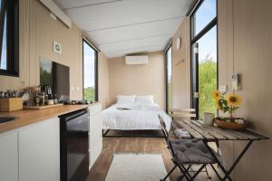 a kitchen with a bed and a table in a room at Revillaging Project by Tiny Away in Boneo