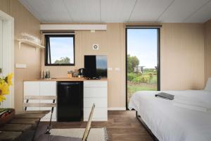 a bedroom with a bed and a kitchen with a counter at Revillaging Project by Tiny Away in Boneo