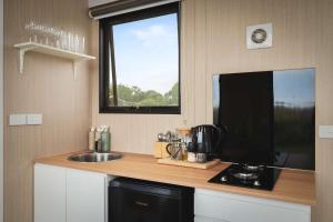 a small kitchen with a sink and a window at Revillaging Project by Tiny Away in Boneo +13 photos
