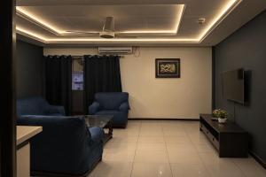 a living room with two chairs and a table at The Nest Apartment in Rawalpindi +4 photos