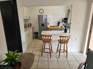 a kitchen with a table and two chairs and a counter at Leopards Tree Garden Cottage in Greytown +11 photos