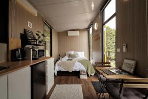 a small bedroom with a bed and a kitchen at Sunset Hill by Tiny Away in Dollar