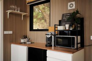 a kitchen with a counter with a microwave and a sink at Sunset Hill by Tiny Away in Dollar