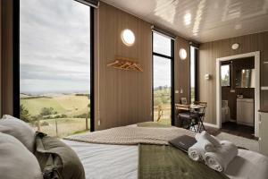 a bedroom with a bed with a large window with a view at Sunset Hill by Tiny Away in Dollar