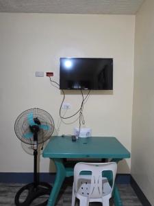 a room with a table and a fan and a tv at La Leona Homestay in Hernani