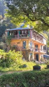 a large yellow house on top of a hill at White Rabbit Guest House in Dharamshala