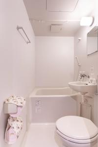 a white bathroom with a toilet and a sink at Saikou in Osaka +77 photos