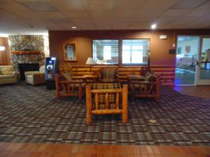 a living room filled with furniture and a large window at American Inn and Suites Houghton Lake in Houghton Lake