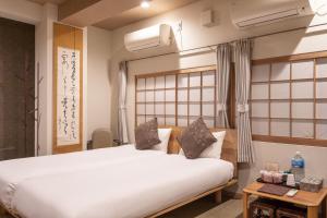 a bedroom with a large white bed in a room at Saikou in Osaka