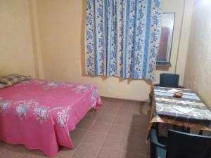 a room with a bed and a table and a window at Hotel Silent River in Ingiriya