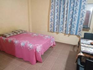 a room with a pink bed and a window at Hotel Silent River in Ingiriya
