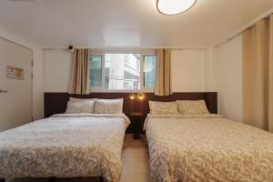 a bedroom with two beds and a window at HeiStay-30sec from Hongdae SubwayStop-Elevator in Seoul +164 photos