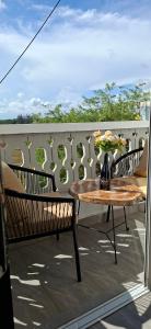 a table and chairs on a balcony with a vase of flowers at Homely studio Apartment 2 in Mombasa