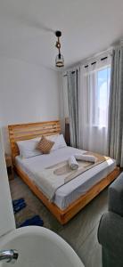 a large bed in a room with a window at Homely studio Apartment 2 in Mombasa +4 photos